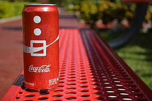 red Coca-Cola can on red surface during daytime