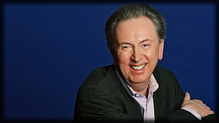 man in black suit jacket smiling
