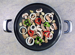 slice of mushroom, green and red chili pepper on cooking pot