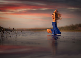 woman in blue dress over body of water