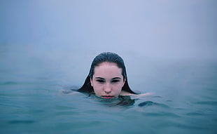 woman swimming on body of water