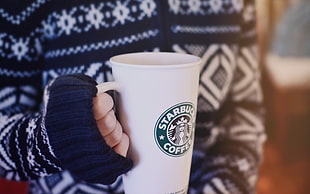 person holding Starbucks Coffee mug