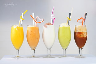 five assorted fruit shakes on glasses