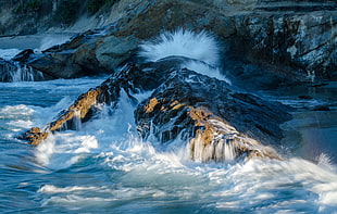 sea waves smashing the brown rocks