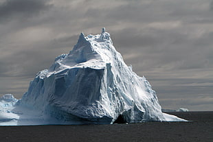 ice berg beside body of water during day time