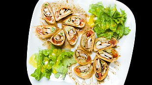 round baked food with green lettuce on plate