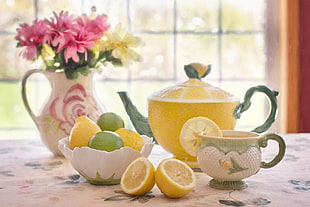 two lemon slices with yellow teapot and cup