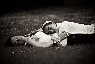 two girls laying on the grass ground during day time
