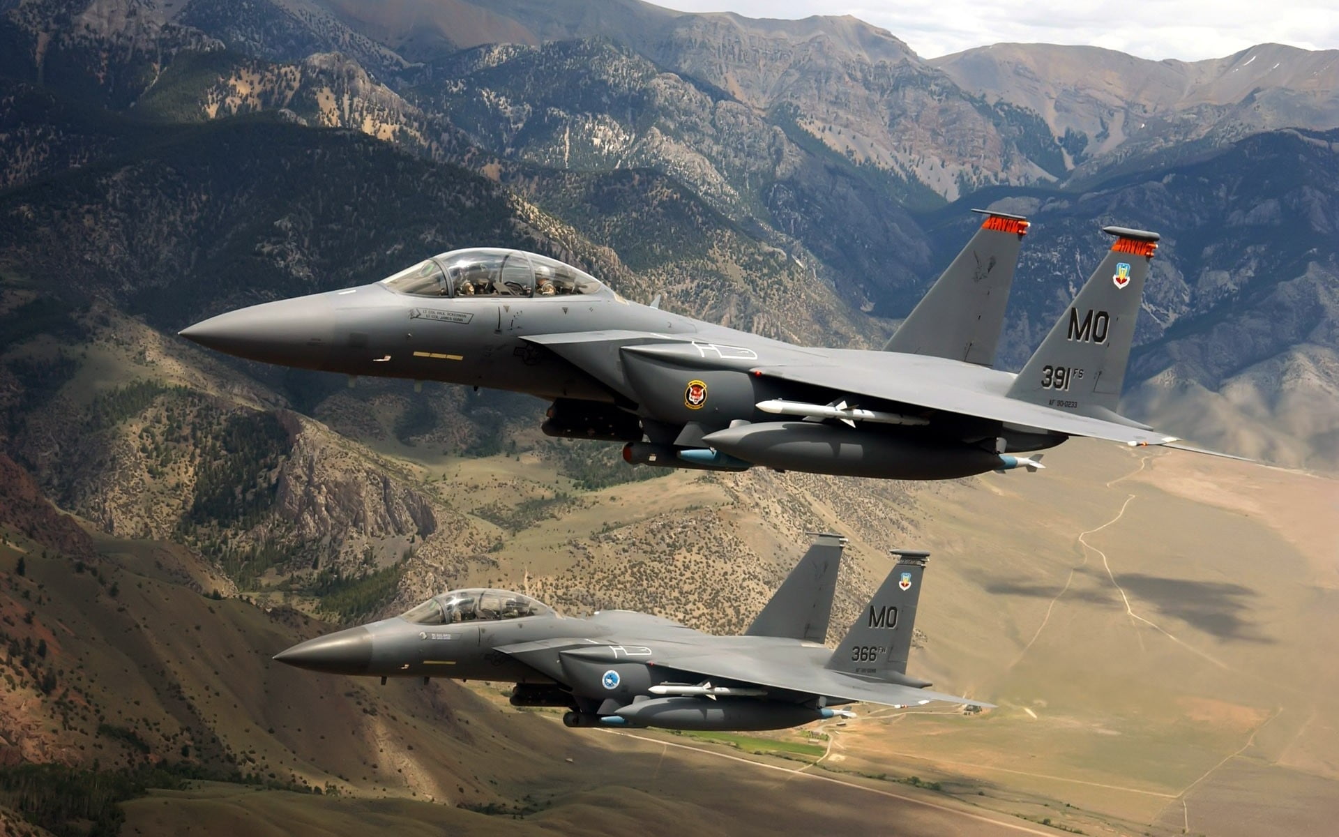two fighter aircraft flying above The mountain