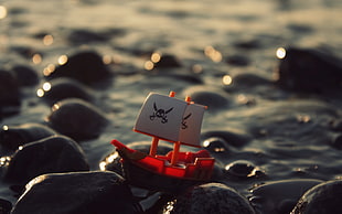 micro shot photography of red and white plastic galleon ship