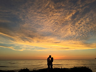silhouette photo of a couple kissing together at seashore