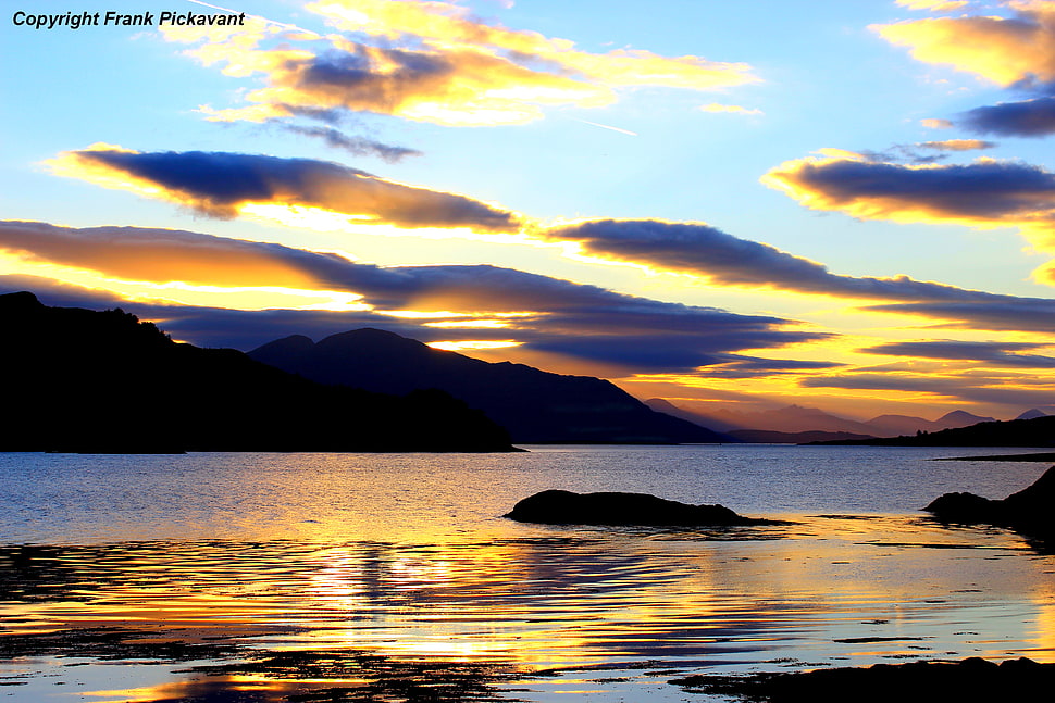 silhouette photography of mountains near body of water during golden hour HD wallpaper