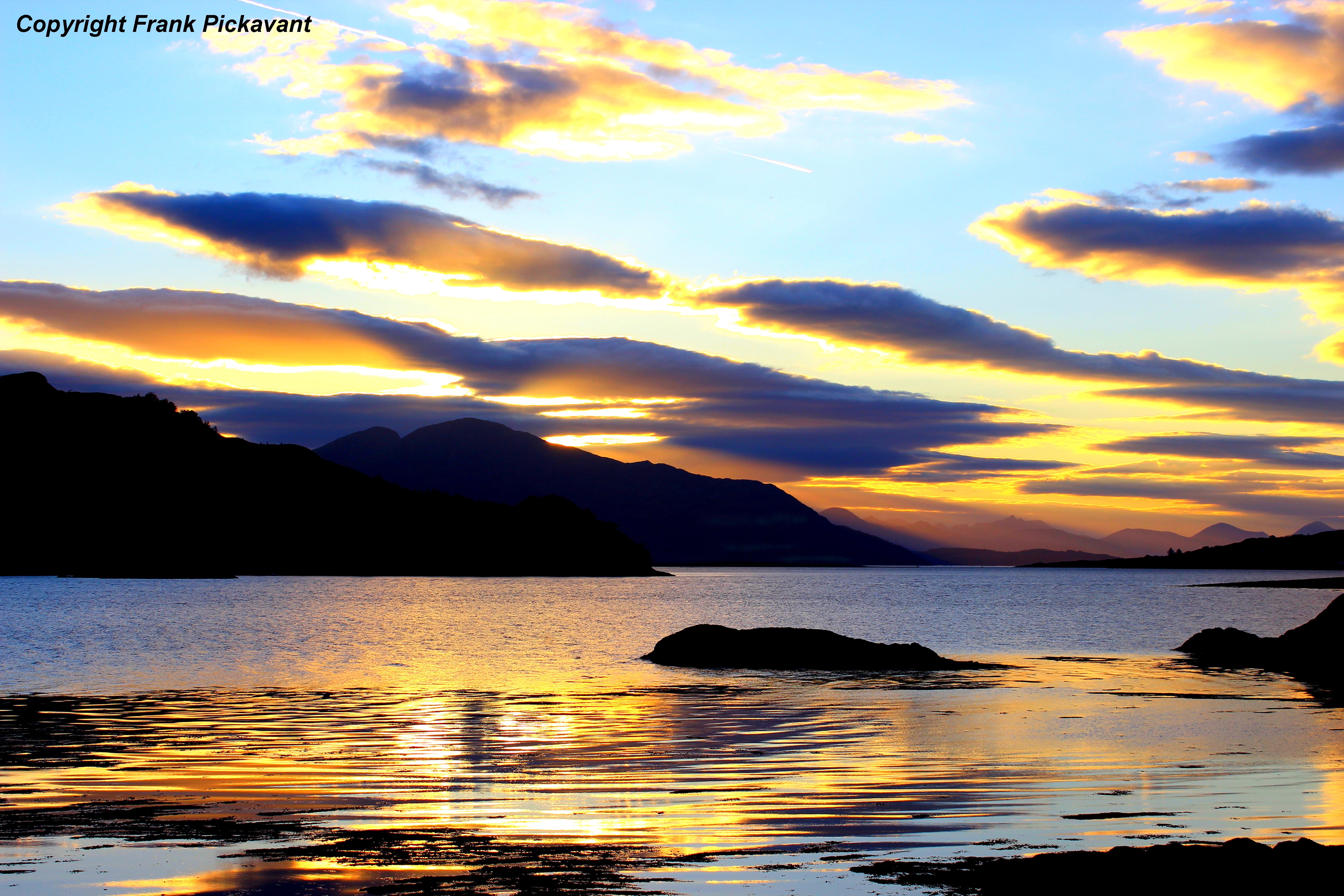 silhouette photography of mountains near body of water during golden hour