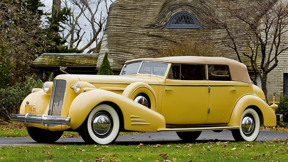 classic yellow sedan on road near brown house during day time HD wallpaper