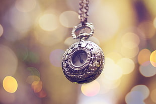 bokeh photography of silver pocket watch