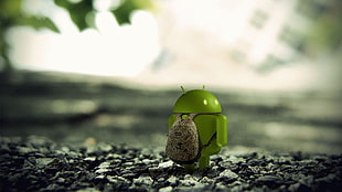 depth of field photography of green Android figure