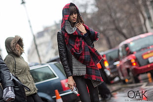 woman in black leather jacket and red and blue plaid scarf