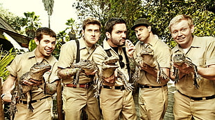 five men holding brown crocodiles
