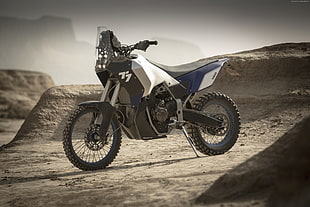 white and blue motocross dirt bike in desert