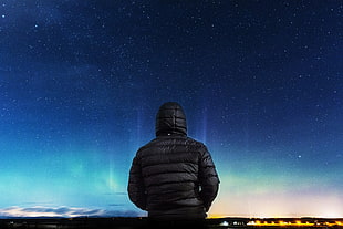 man wearing black hoodie watching aurora borealis