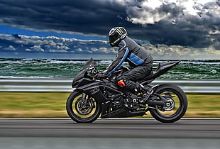 man riding motorcycle on road near beach