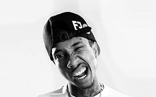 grayscale photo of man wearing cap and crew-neck shirt
