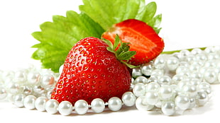 strawberry beside of white beaded necklac