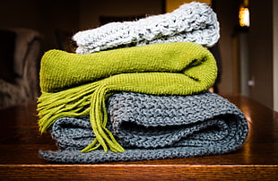 three white, green, and gray crochet textiles