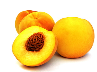 sliced and three round orange-colored fruits