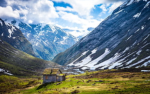landscape photo of gray cabin with mountain background