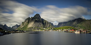 mountains beside body of water and cloudy sky, reine