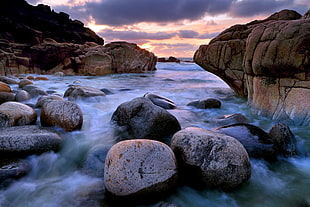 time-lapse photography of body of water with rocks during daytime HD wallpaper