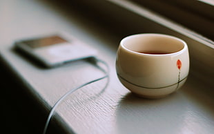 selective focus photography of white ceramic cup