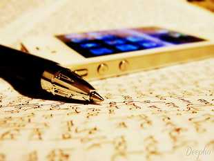 black ballpoint pen beside gold iPhone 5S