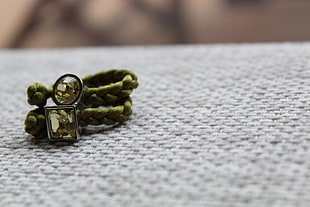 two green paracord bracelets on white textile