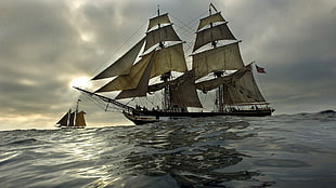 photography of brown and white galleon ship on body of water under cloudy sky