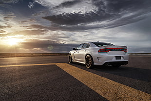 white car parked on gray pavement under gray clouds at daytime HD wallpaper
