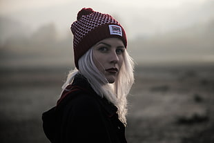 woman in maroon coat and knit cap