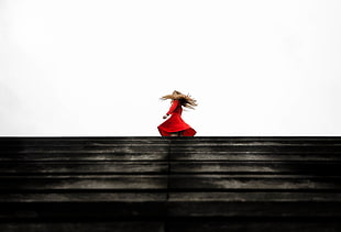person wearing dress on top of stairs against white background