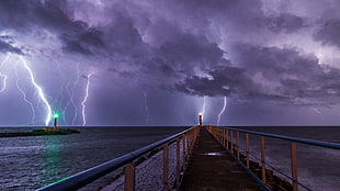 photography of metal bridge under thunder