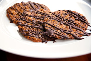 baked cookies drizzled with chocolate liquid on ceramic plate HD wallpaper