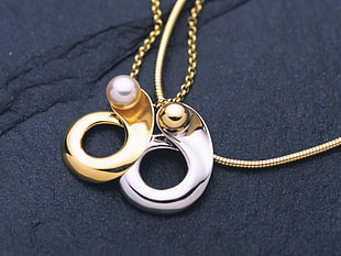 gold-colored and silver-colored pendant necklaces