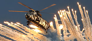 black and white helicopter escaping a explosion during daytime HD wallpaper