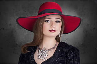 woman wearing red hat and black scoop-neck dress