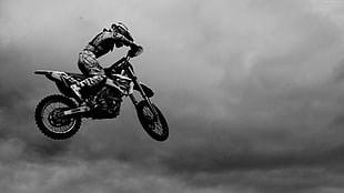 grayscale sports photography of motocross rider suspended on air