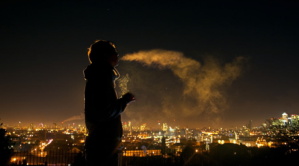 silhouette of man smoking during nighttime HD wallpaper