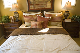 bed between two brown wooden nightstands