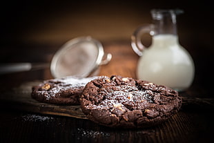 two chocolate cookies on brown wooden table