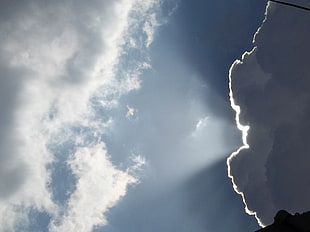 white and black stone fragment, clouds, lights, sky, flashlight