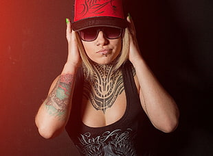 woman wearing red fitted cap and black and grey printed tank top